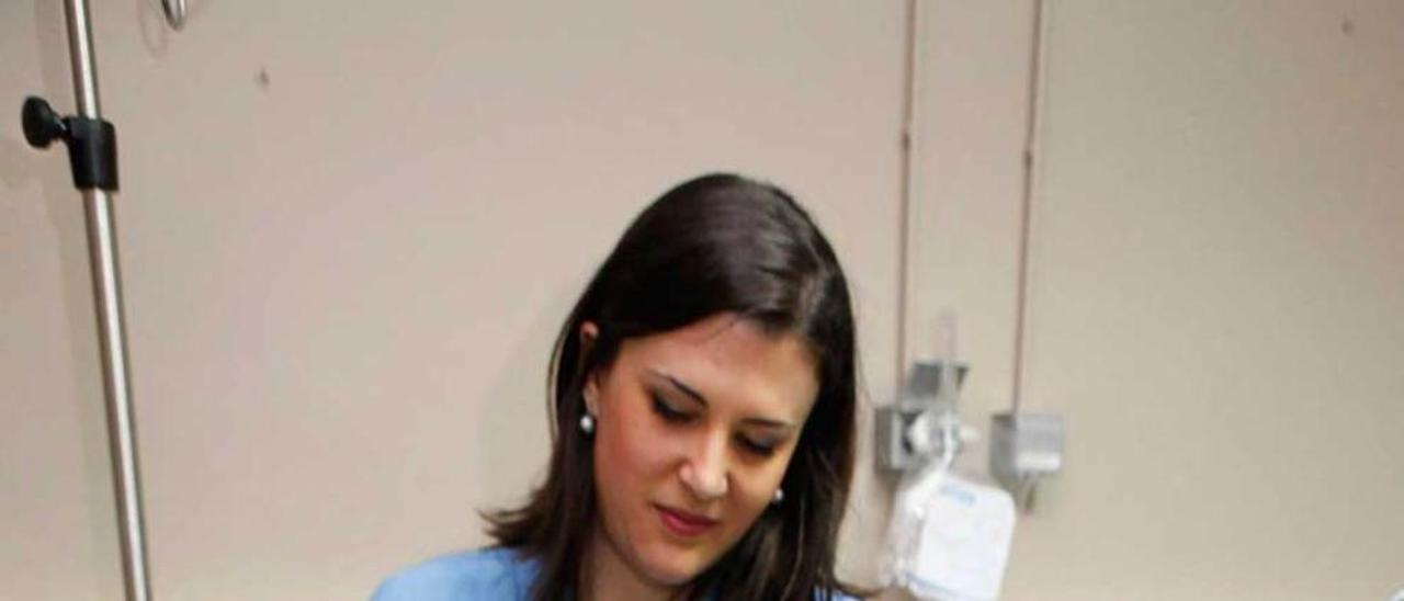 La enfermera Lara Quesada coloca el gorro de hipotermia a Laura Pérez.