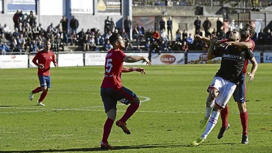 Yeray (en el centro), durante el partido del pasado domingo en el que se observa el mal estado del césped.