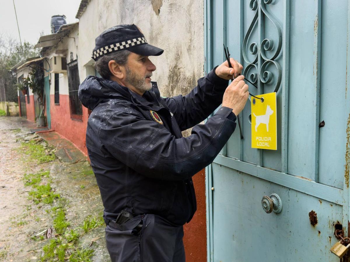 Un policía local coloca una señal de animales en la vivienda en una casa potencialmente inundable, este miércoles en Córdoba.