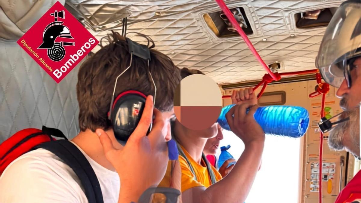 Los excursionistas rescatados se hidratan en el helicóptero