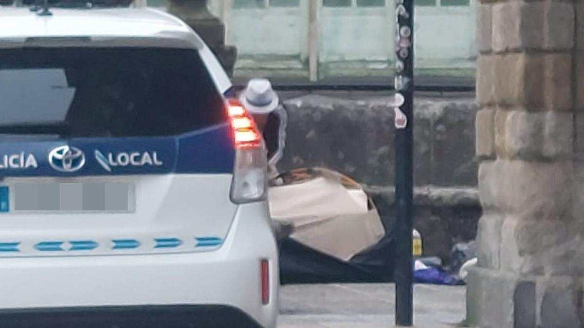 Imagen del hombre este martes recogiendo su tienda de campaña en el Obradoiro para ser desalojado por la Policía Local