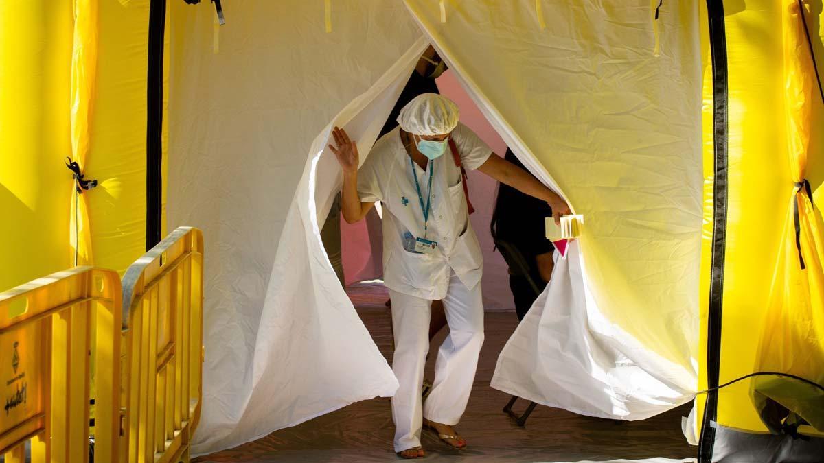 Máximo de contagios por coronavirus en España en un día: 1.772. En la foto, una sanitaria sale de una de las carpas instaladas para hacer pruebas PCR en Ripollet.