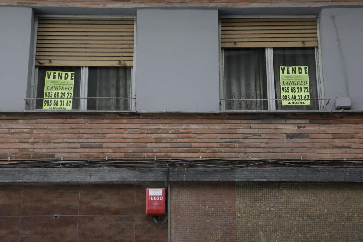 Carteles anunciando pisos en venta en Langreo