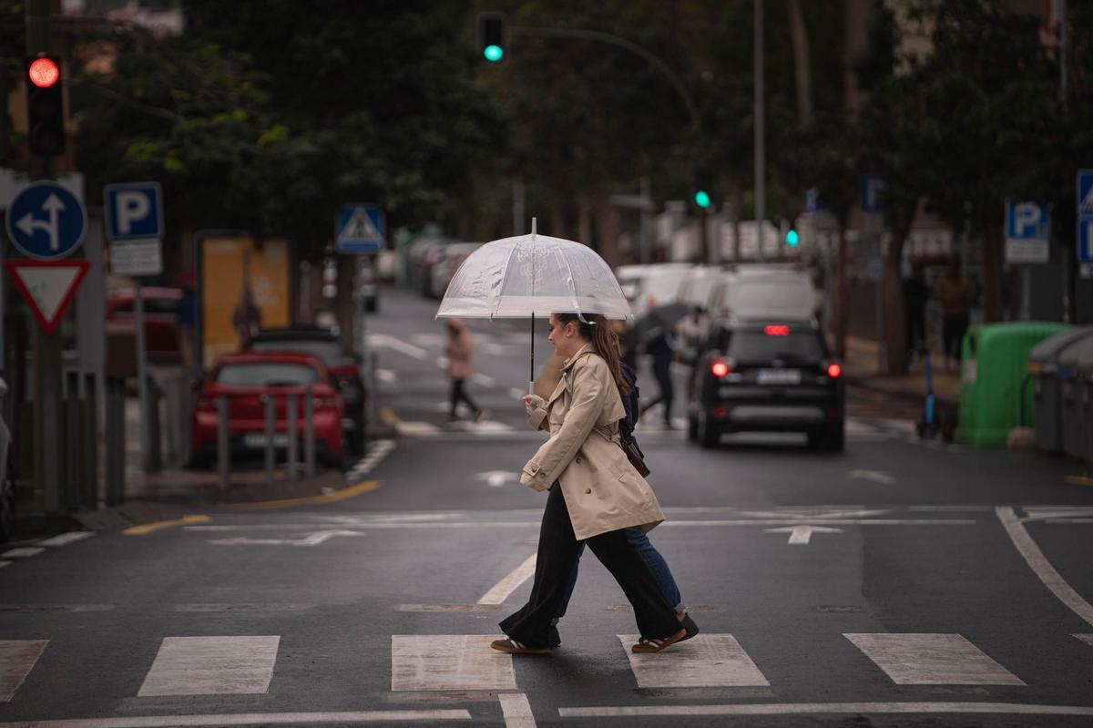Unas chicas se protegen de la lluvia en Santa Cruz de Tenerife.