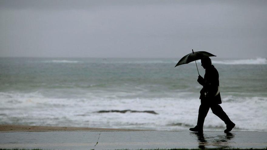 Un hombre camina por el paseo marítimo, a la altura de la playa de Riazor.