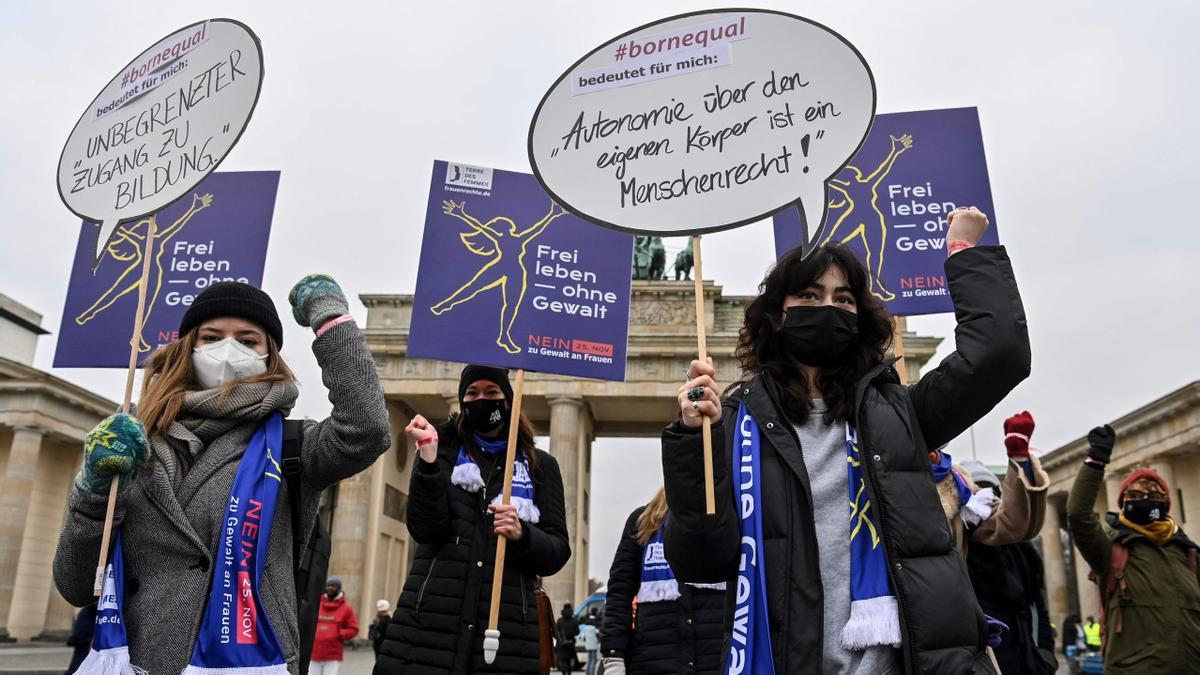 Unas manifestantes sostienen un cartel que dice la autonomía sobre su propio cuerpo es un derecho humano durante una manifestación contra la violencia contra las mujeres convocada por la organización de derechos de las mujeres Terre des Femmes frente a la Puerta de Brandenburgo en Berlín, el 25 de noviembre de 2021.