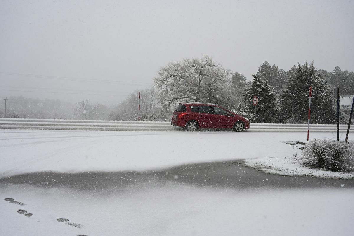 Un coche transita entre la nieve por la carretera N 630 en una jornada nubosa marcada por el temporal de nieve en la provincia de León. EFE/J.Casares