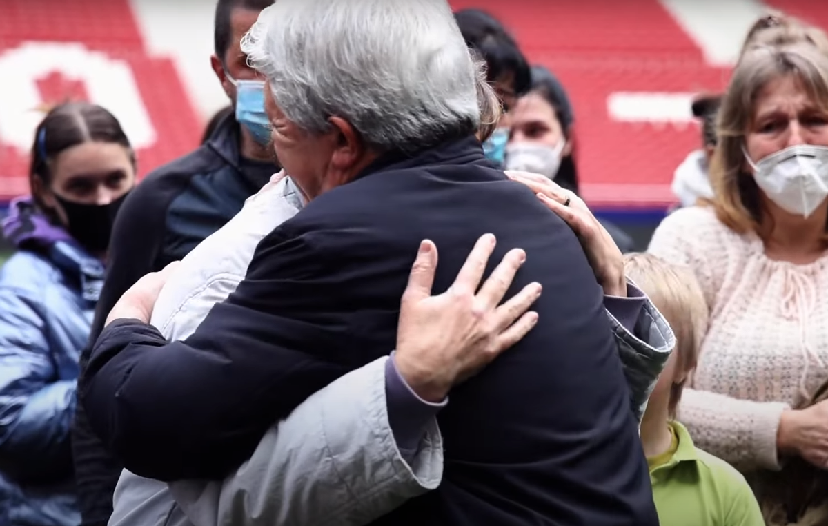 Juan Carlos Cerezo, presidente del Atlético de Madrid, abraza a una refugiada ucraniana.