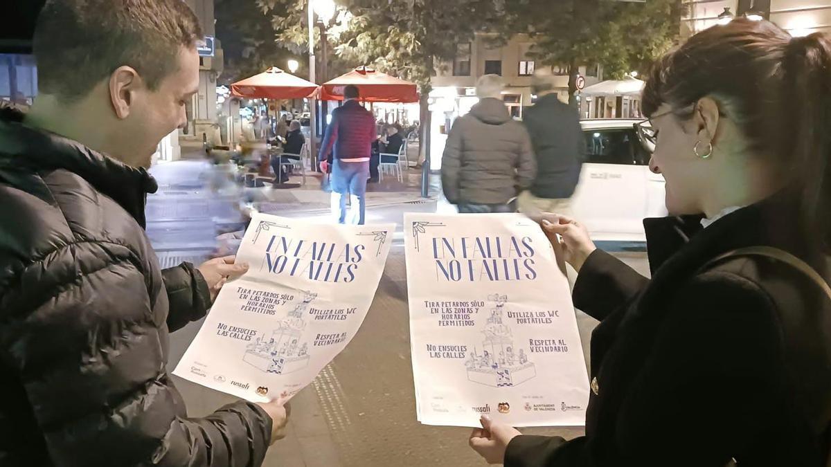 Dos jóvenes miran dos carteles de los que se pegarán en bares y locales de ocio.