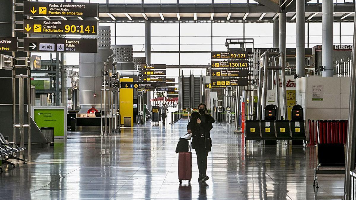 Una pasajera camina ayer por la desolada terminal del aeropuerto donde solo hubo 3 vuelos. | HÉCTOR FUENTES