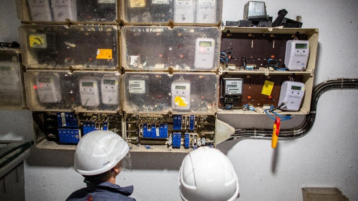 Unos operarios revisan contadores de electricidad.