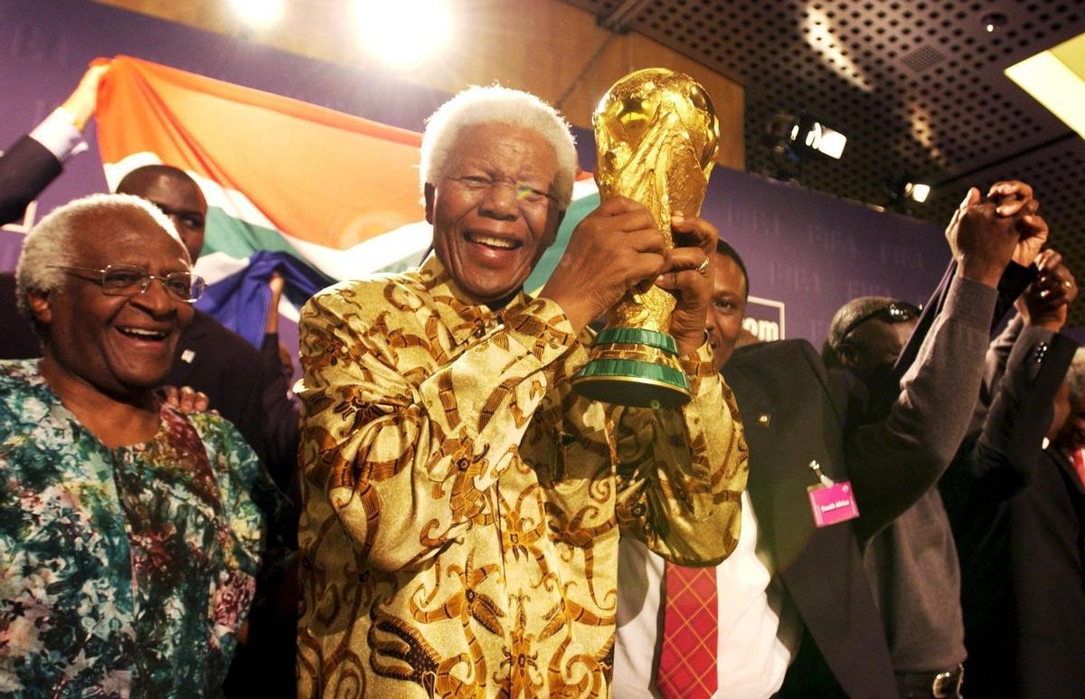 (Switzerland Schweiz Suisse), 26/12/2021.- (FILE) - Former South African President Nelson Mandela, centre, Archbishop Desmond Tutu, left, and other members of the South African delegation celebrate after it was announced by the World Football Association FIFA, that South Africa will host the 2010 soccer World Cup, in Switzerland, 15 May 2004 (reissued 26 December 2021). Desmond Tutu has died aged 90, the South African presidency said on 26 December 2021. As a leading spokesperson for the rights of black South Africans, Tutu in 1984 received the Nobel Prize for Peace for his role in the opposition to apartheid in South Africa. (Mundial de Fútbol, Sudáfrica, Suiza) EFE/EPA/STR DATABASE; NO SALES; NO ARCHIVES;