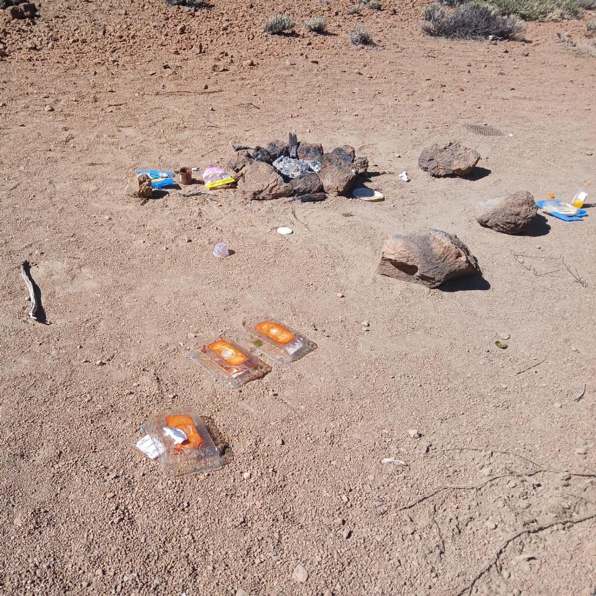 Basura alrededor de la hoguera que dejaron los últimos visitantes del Teide que protagonizan un acto incívico e irregular.