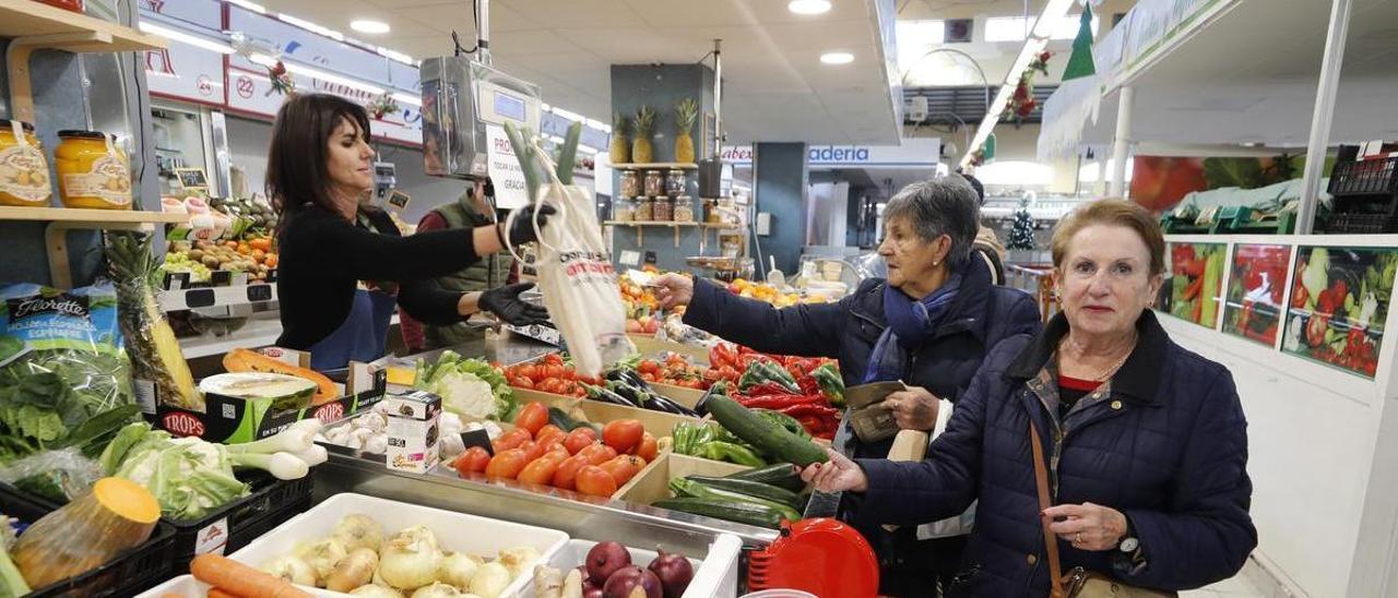 Dos mujeres compran en una frutería del marcado de Teis, en Vigo.