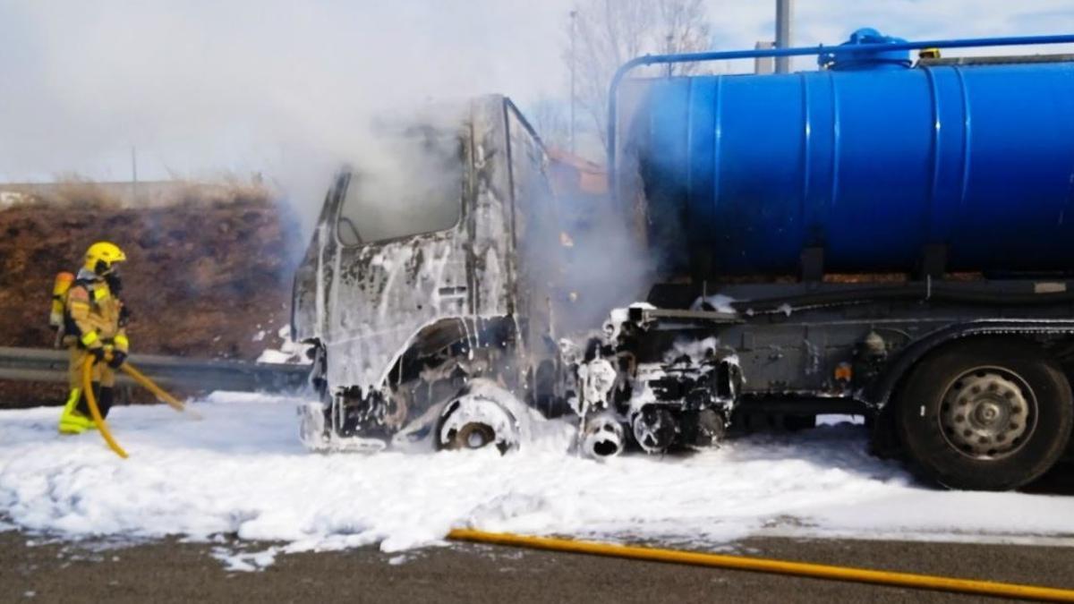 Efectius dels Bombers treballant en les tasques d'extinció del vehicle incendiat a l'eix Transversal, a Sant Fruitós de Bages