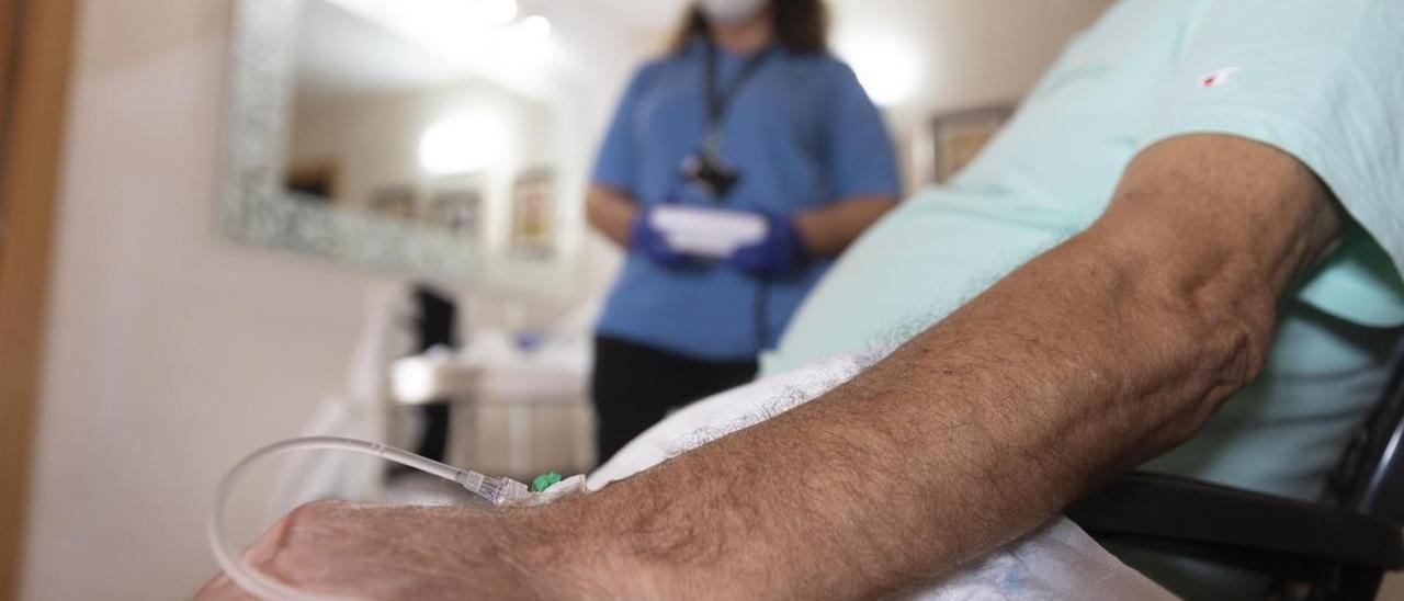 Una enfermera del Clínic atiende a un paciente que está en hospitalización domiciliaria.