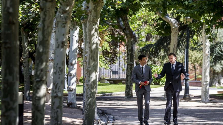 El presidente del Gobierno, Mariano Rajoy, pasea con Miguel Ángel López por los jardines de la Moncloa