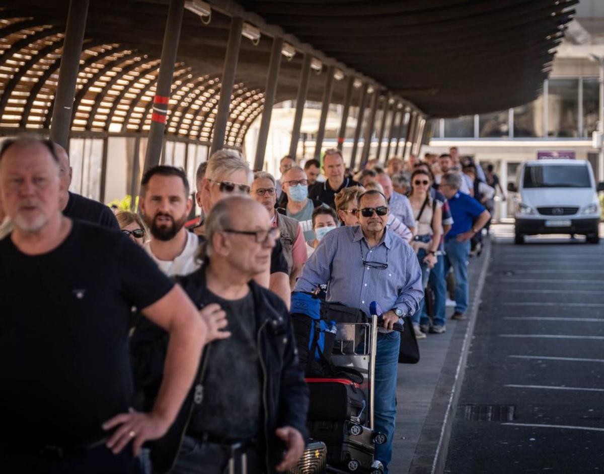 Turistas esperan un taxi en la parada del Aeropuerto Tenerife Sur. | | ANDRÉS GUTIÉRREZ