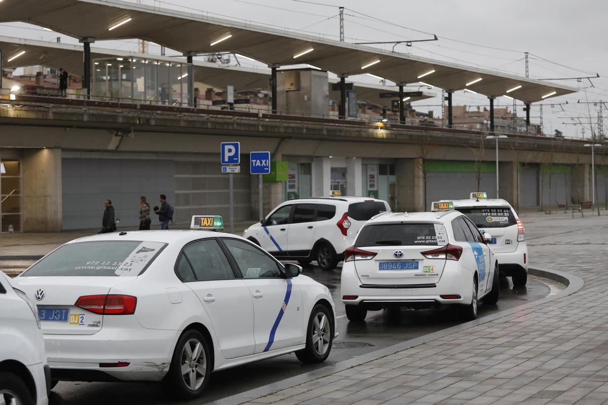 Taxis esperant clients al parc Central, entre les estacions de trens.
