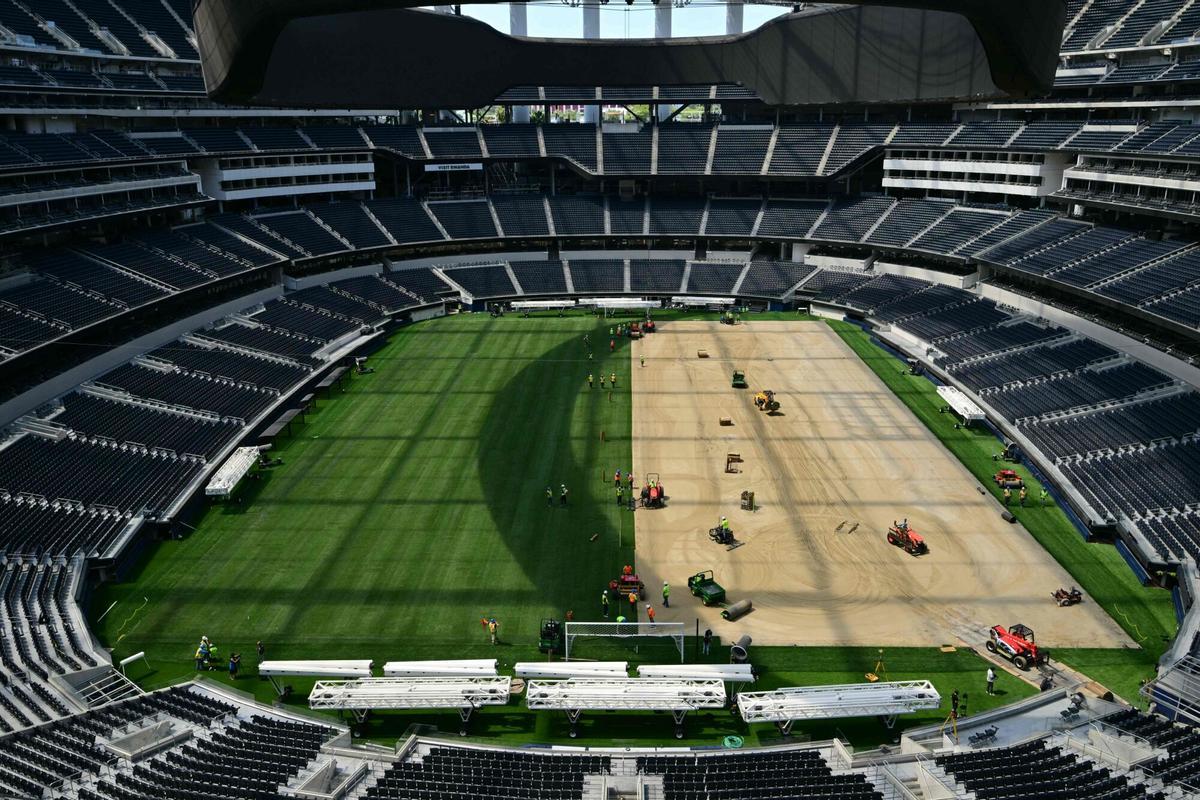 Los trabajadores instalan césped en el campo en el SoFi Stadium en Inglewood, California, antes de su cambio de nombre temporal al Estadio de Los Ángeles para la Copa del Mundo el 13 de mayo de 2026.
