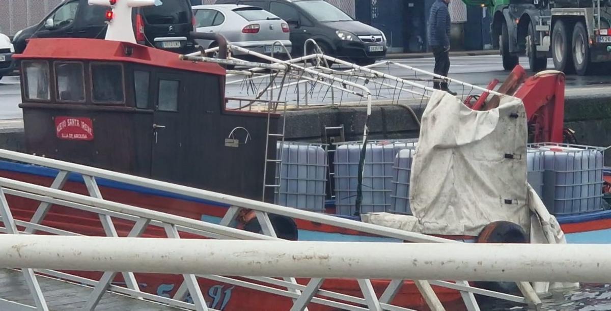 El barco con los depósitos a bordo en el muelle de Rianxo