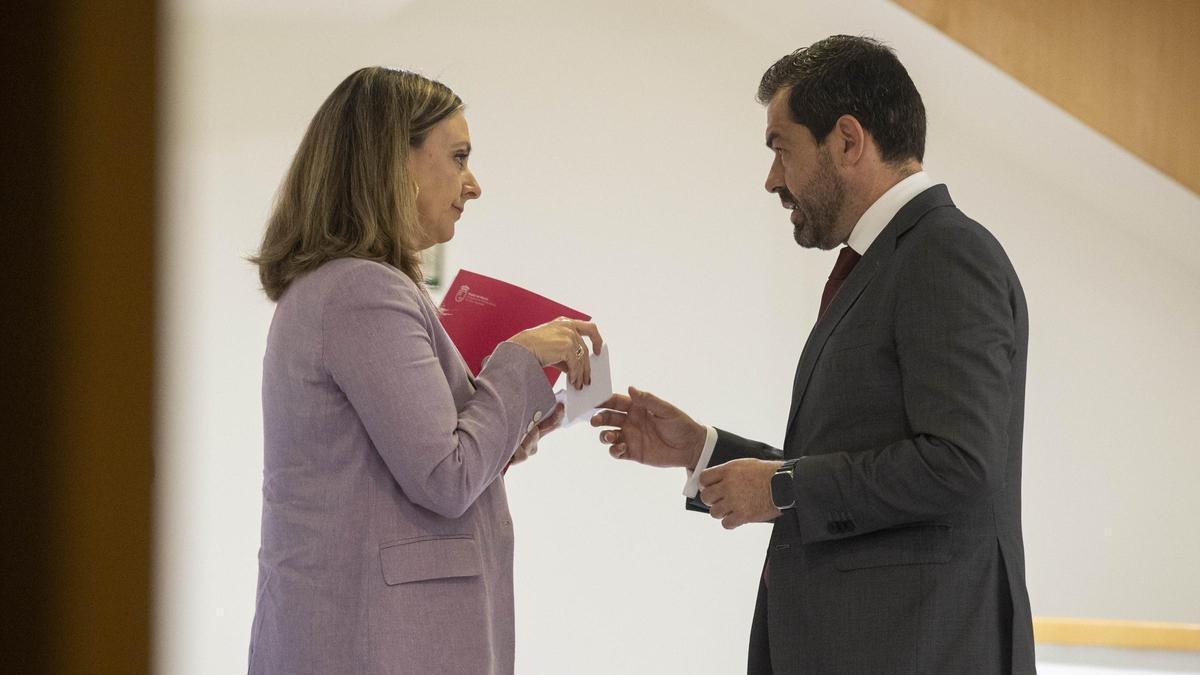 La consejera de Política Social, Conchita Ruiz, intercambia unas notas con el diputado de Vox Rubén Martínez Alpañez durante el Pleno.