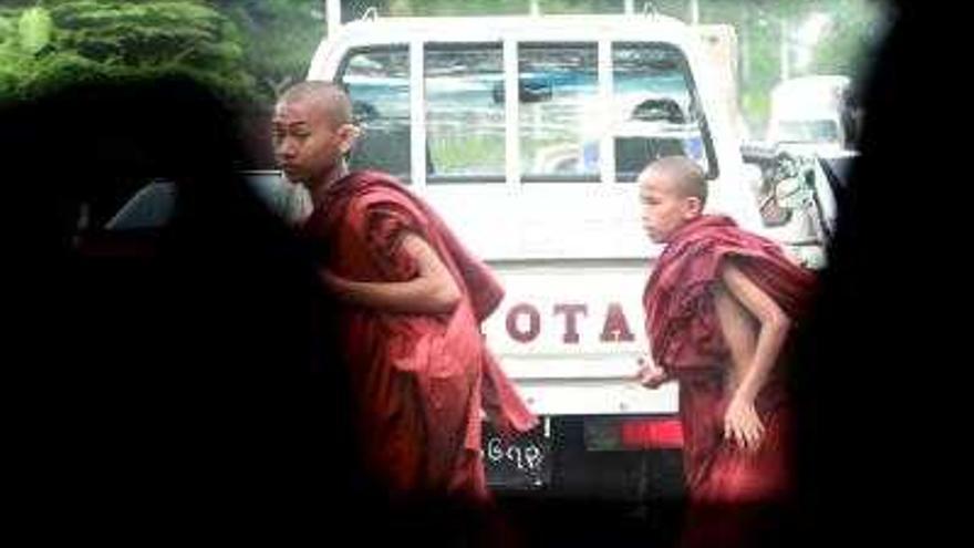 Monjes budistas atraviesan una calle de Yangon. Según las emisoras de la disidencia, algunos grupos de soldados extorsionan a transeúntes y comerciantes en Rangún bajo amenaza de arresto, al amparo de la persecución acometida por la Junta Militar de Birmania (Myanmar) contra los manifestantes que desafiaron al régimen y los periodistas que informaron.