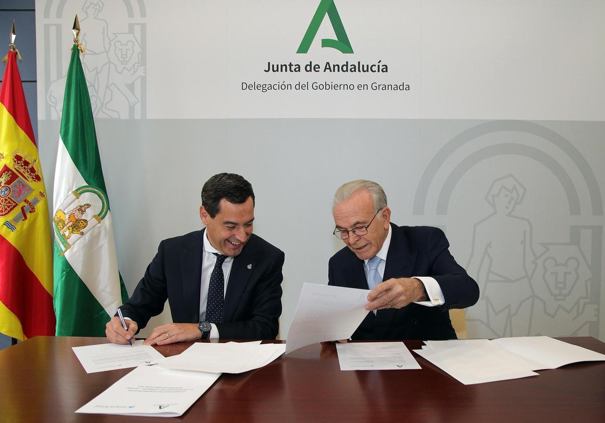 El presidente de la Junta de Andalucía, Juanma Moreno, y el presidente de la Fundación "la Caixa", Isidro Fainé, en la firma del convenio marco entre ambas instituciones en Granada.