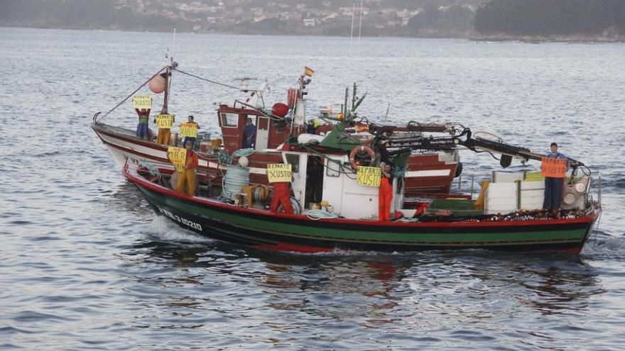 Dos de los barcos del cerco de Bueu saliendo hoy con pancartas para pedir un reparto justo. Santos Álvarez