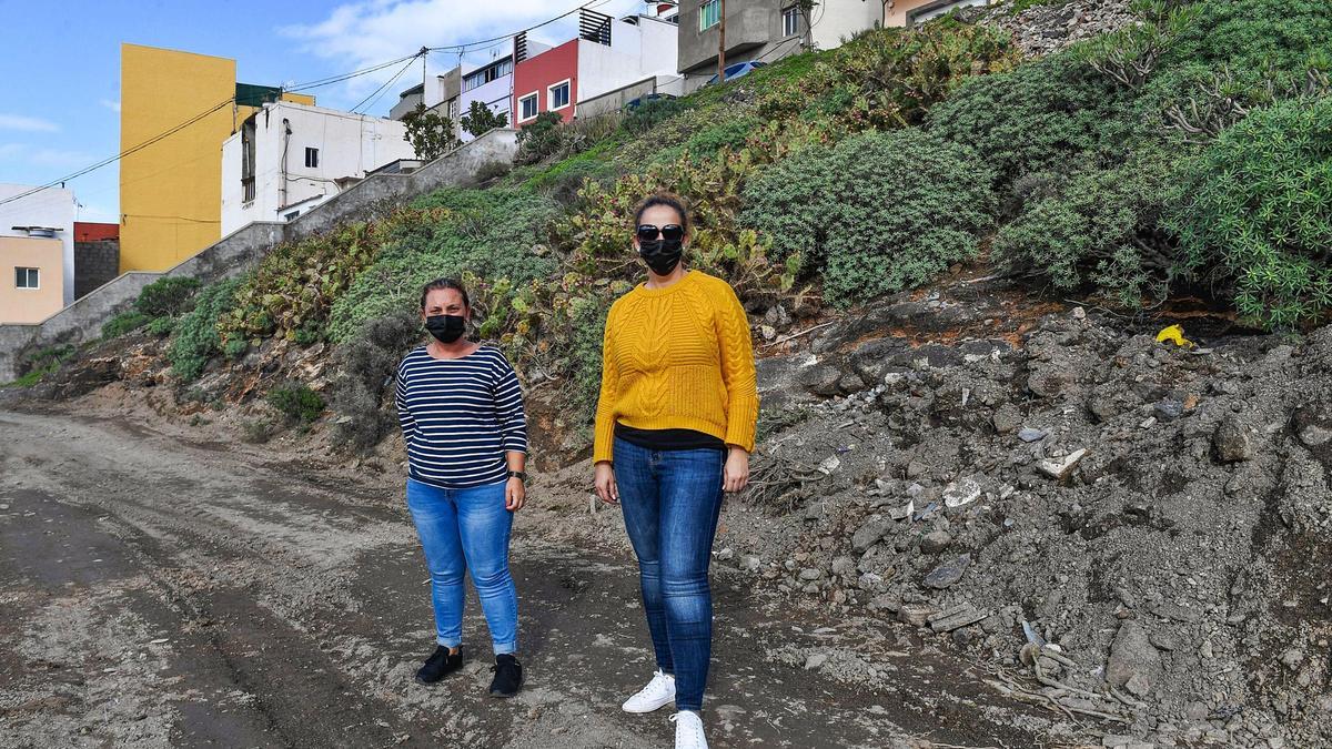 Francisca Rodríguez y Diana Déniz, vecinas de la calle La Peña, en Ladera Alta, ayer, quienes el domingo quedaron aisladas por la lluvia al carecer de una vía urbanizada.