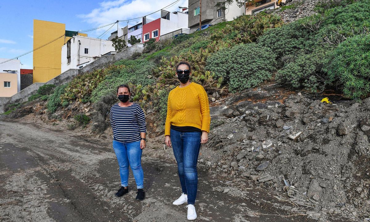 Francisca Rodríguez y Diana Déniz, vecinas de la calle La Peña, en Ladera Alta, ayer, quienes el domingo quedaron aisladas por la lluvia al carecer de una vía urbanizada.