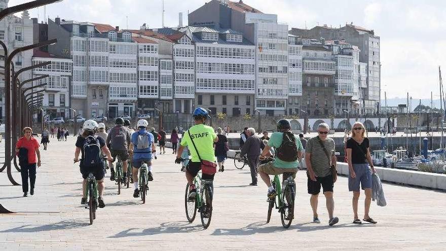 Turistas caminan por la Marina de A Coruña.