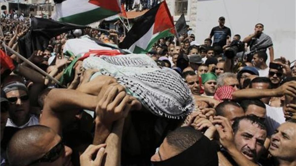 Palestinos cargan con el cuerpo del joven Mohamad Abu Jedeir, durante su funeral.