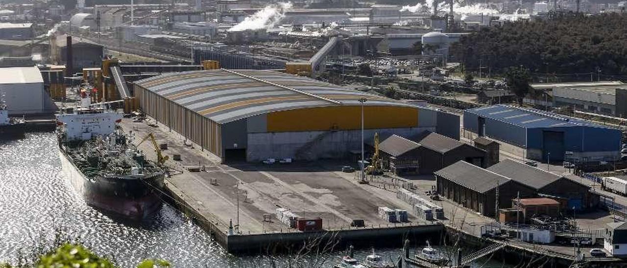 Un mercante en los muelles de Raíces, junto a los almacenes de Asturiana de Zinc.