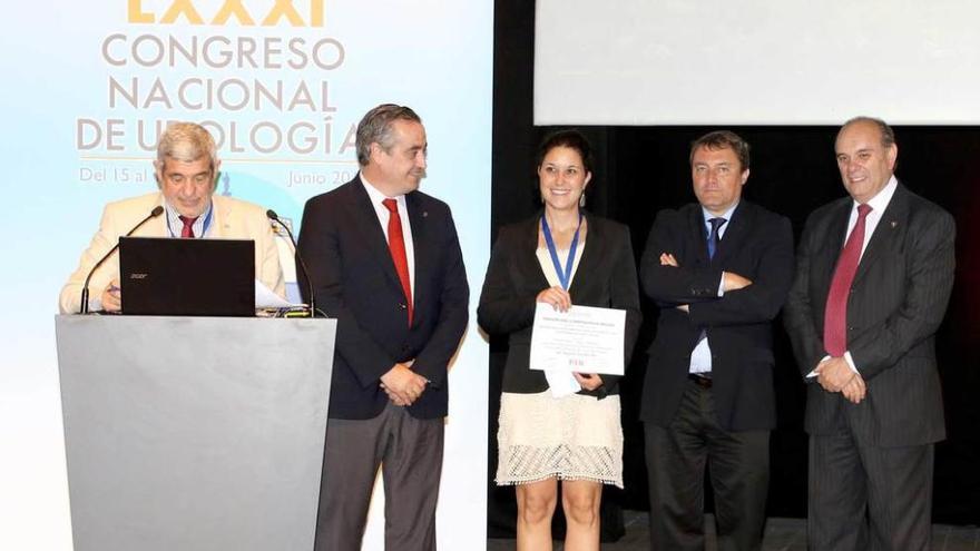 La doctora Begoña Díaz recibe el premio de manos del presidente de la Asociación Española de Urología, el doctor José Manuel Cózar.