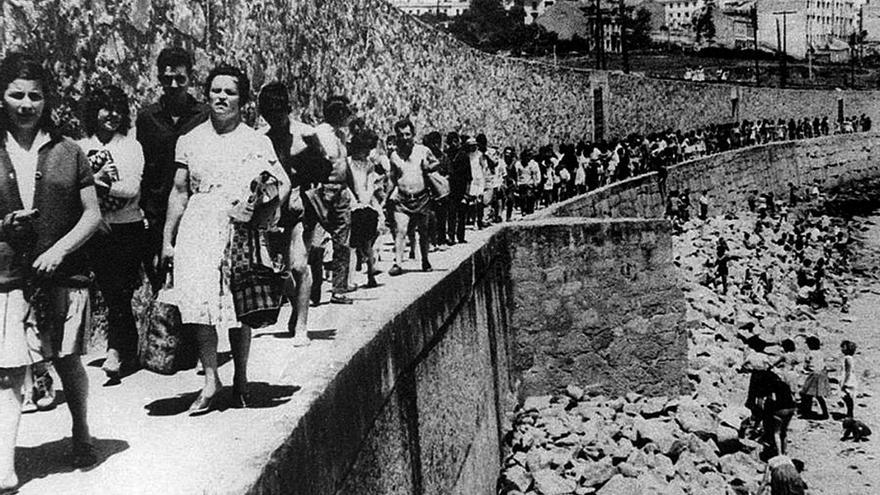 Bañistas camiñando cara a desaparecida praia do Lazareto. | La Opinión