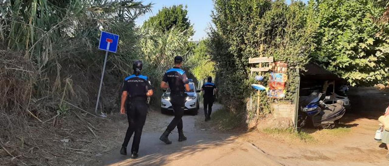 La Guardia Civil y la Policía Local de Cangas, ayer, en el camino de acceso a la playa en la que apareció el cráneo.   | // FDV