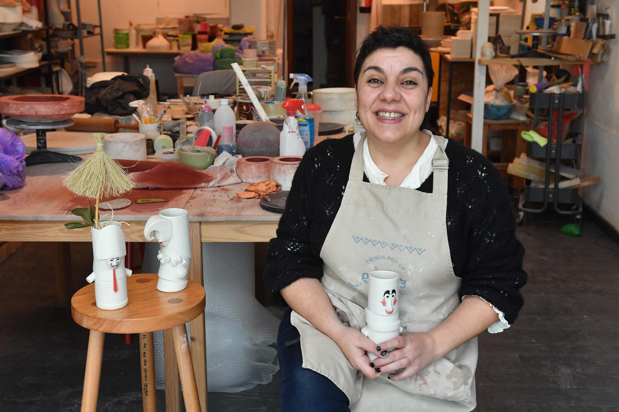 Laura Delgado con los vasos tiki ganadores, una combinación de culturas entre Polinesia y Galicia, y otras obras realizadas por esta ceramista en su taller de Cambre, en el que también da clases a pequeños grupos.