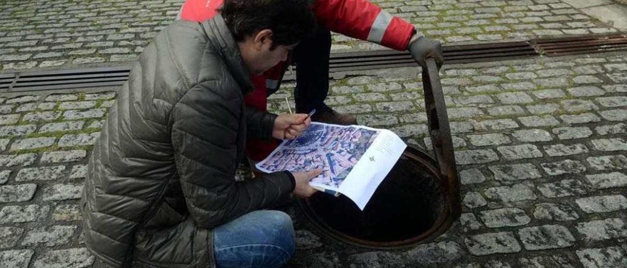 Técnicos municipales constatan en Carril el estado de la red de saneamiento. // Noé Parga