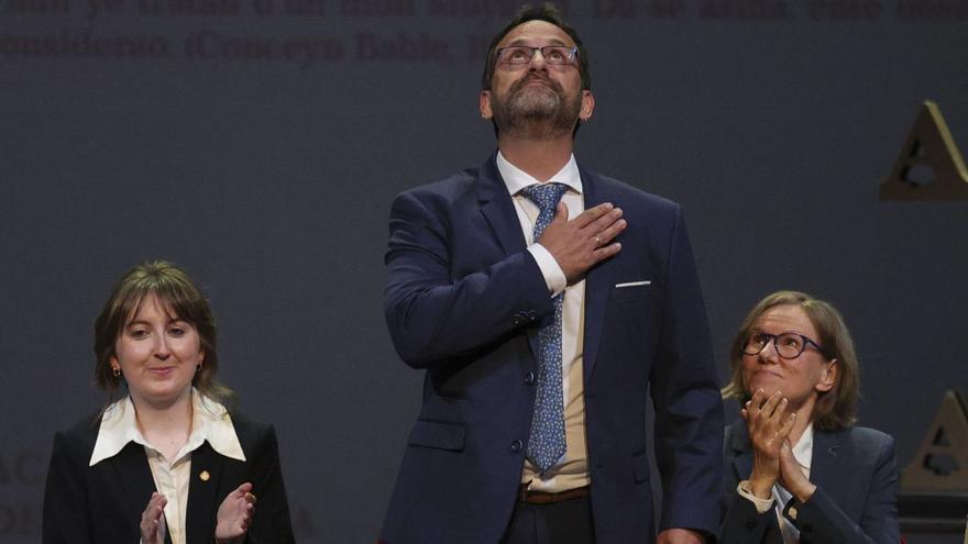 Pablo Rodríguez, de pie y con la mano en el corazón, al término de la lectura de su discurso de ingreso, entre Claudia Elena Menéndez, a la izquierda, y Éva Buchi