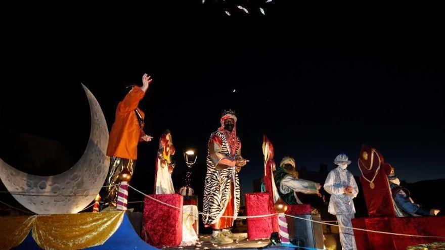 Los Reyes arrojan caramelos durante su recorrido desde la plaza de la iglesia.