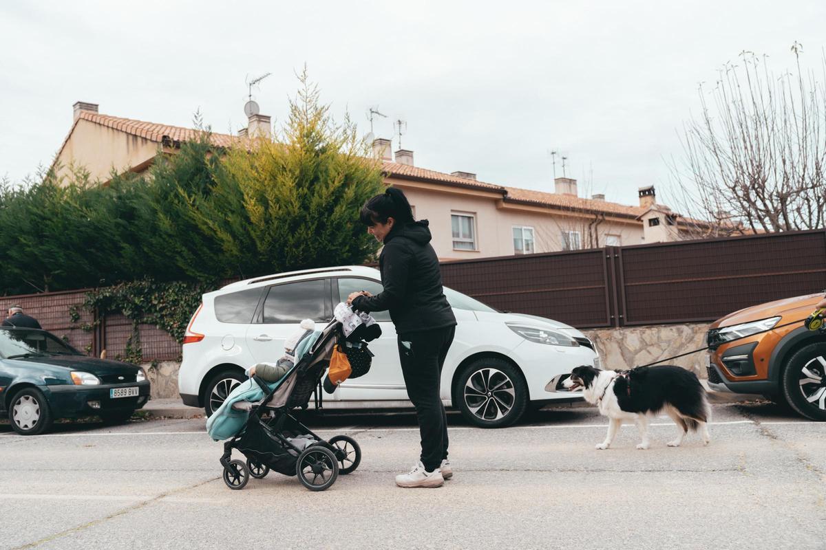 Sheila, vecina de Hontanares de Eresma, el pueblo más joven de España, pasea con su niño por la urbanización de chalés donde vive.