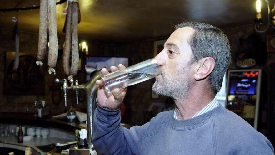 Un vecino bebe un vaso de agua en un establecimiento público de Cerdedo. // Bernabé/Javier Lalín