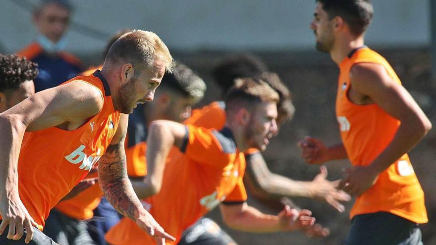 Varios futbolistas del Valencia CF, durante el entrenamiento de ayer en Paterna.