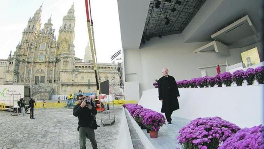 El arzobispo de Santiago, Julián Barrio, inspecciona el altar levantado para la misa que oficiará hoy el Papa en la plaza del Obradoiro de Santiago. / fdv