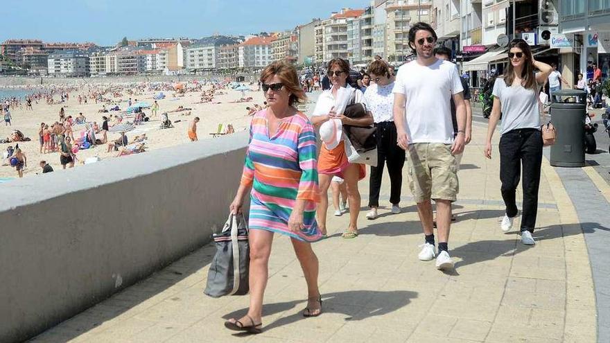 Varias personas disfrutan del buen tiempo en el paseo de Silgar. // Rafa Vázquez