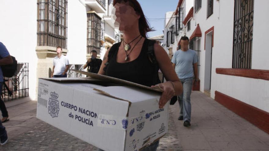 Una investigadora de la Udyco transporta cajas con documentos del Consistorio.