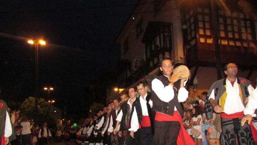 La hoguera de la Magdalena, a hombros de los porruanos por las calles de Llanes, ayer.