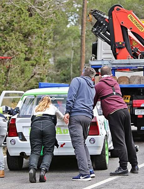 Operarios de la organización retiran un coche accidentado.