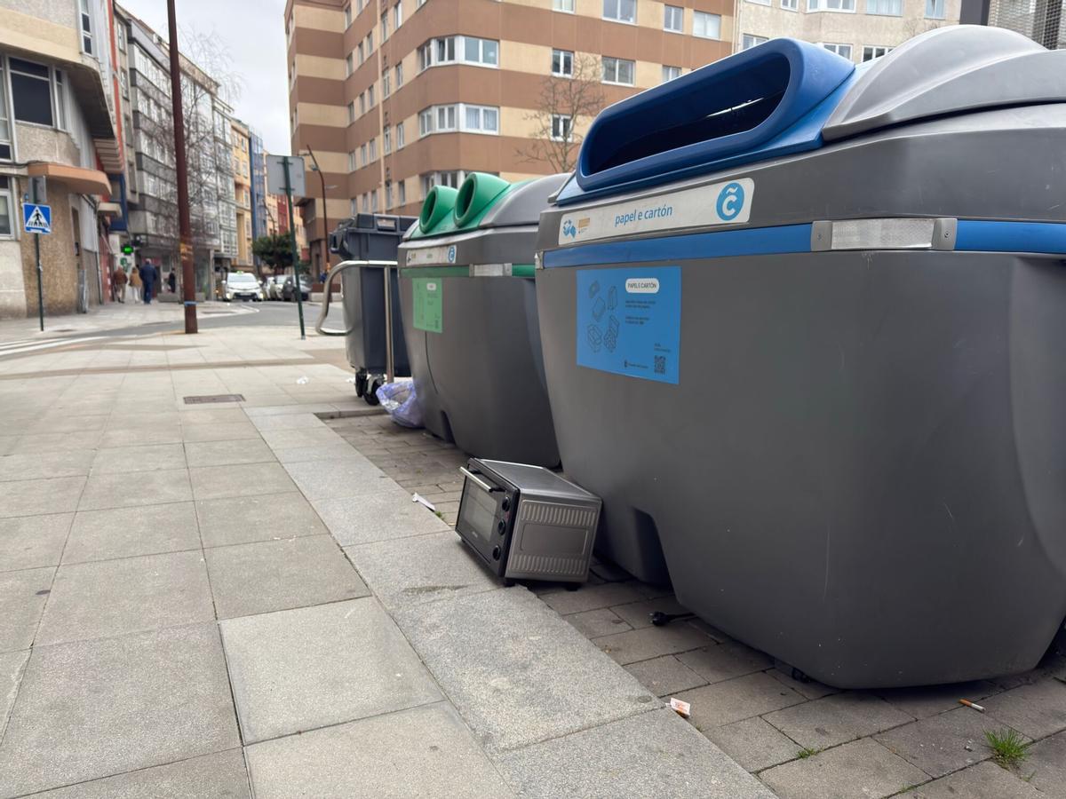 El microondas, apoyado contra un contenedor de papel en la calle Orillamar.